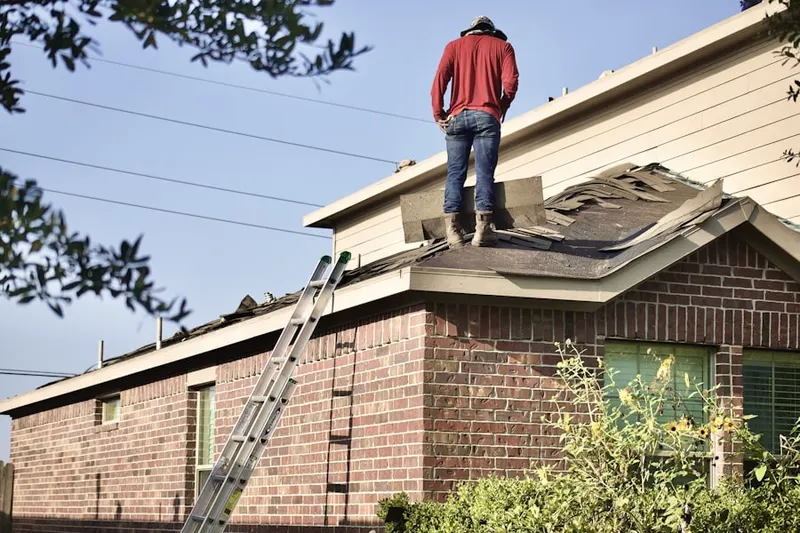 Professional roofer working on a residential roof in Kermit